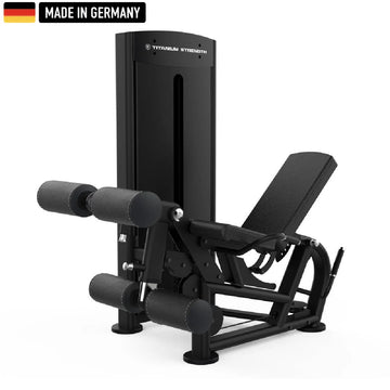 A sleek, black Titanium Strength gym machine with padded leg supports and adjustable features, labeled "Made in Germany."