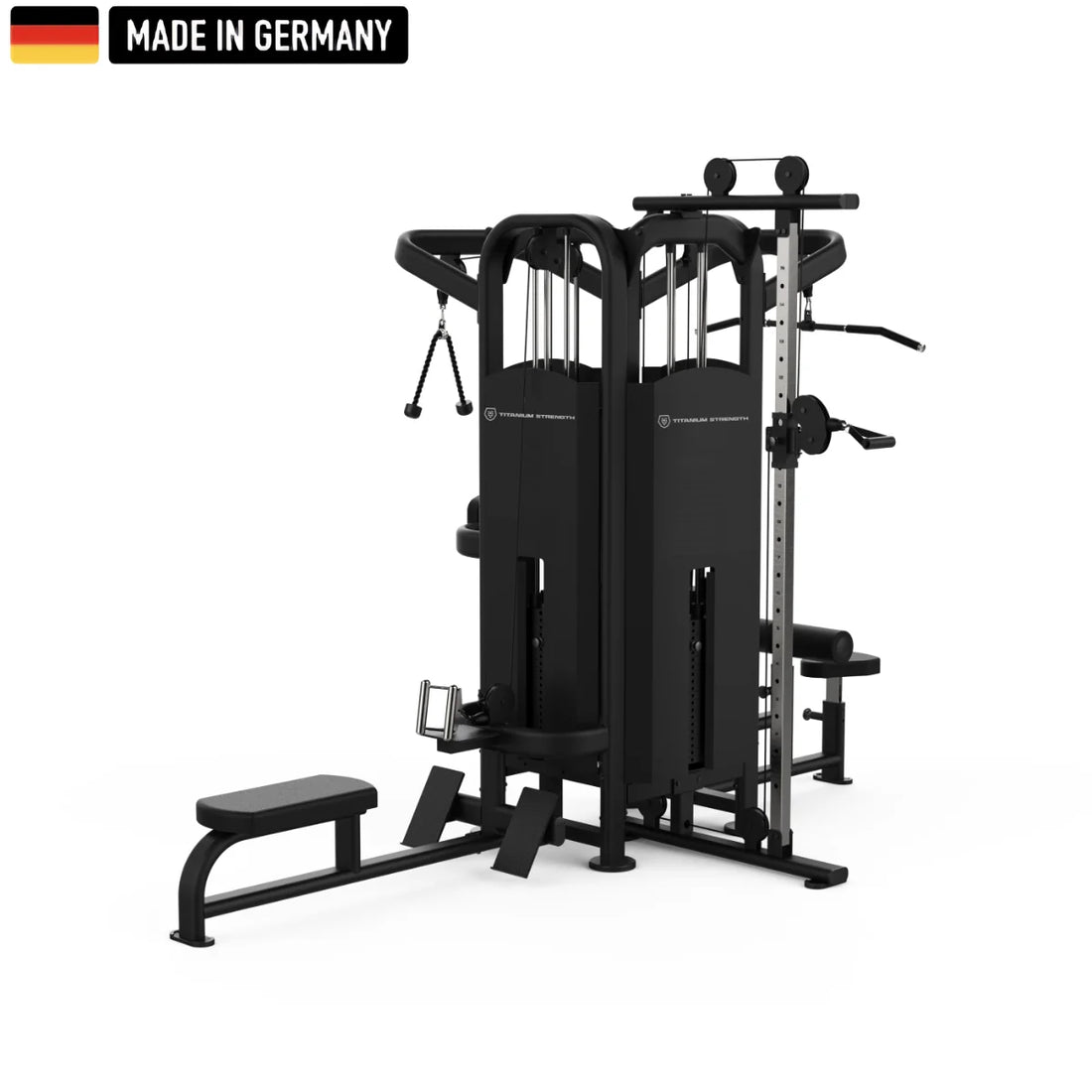 Multi-functional black gym machine with various attachments, including a cable pulley system, adjustable weight stacks, a seated row station, and a Smith machine bar. The equipment is labeled "Titanium Strength" and features a "Made in Germany" badge with the German flag in the top left corner.