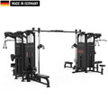 Large multi-station gym machine in black, featuring multiple cable pulleys, adjustable weight stacks, pull-up bars, seated row stations, and Smith machine bars. The equipment is branded 