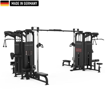 Large multi-station gym machine in black, featuring multiple cable pulleys, adjustable weight stacks, pull-up bars, seated row stations, and Smith machine bars. The equipment is branded "Titanium Strength" and includes a "Made in Germany" badge with the German flag in the top left corner.